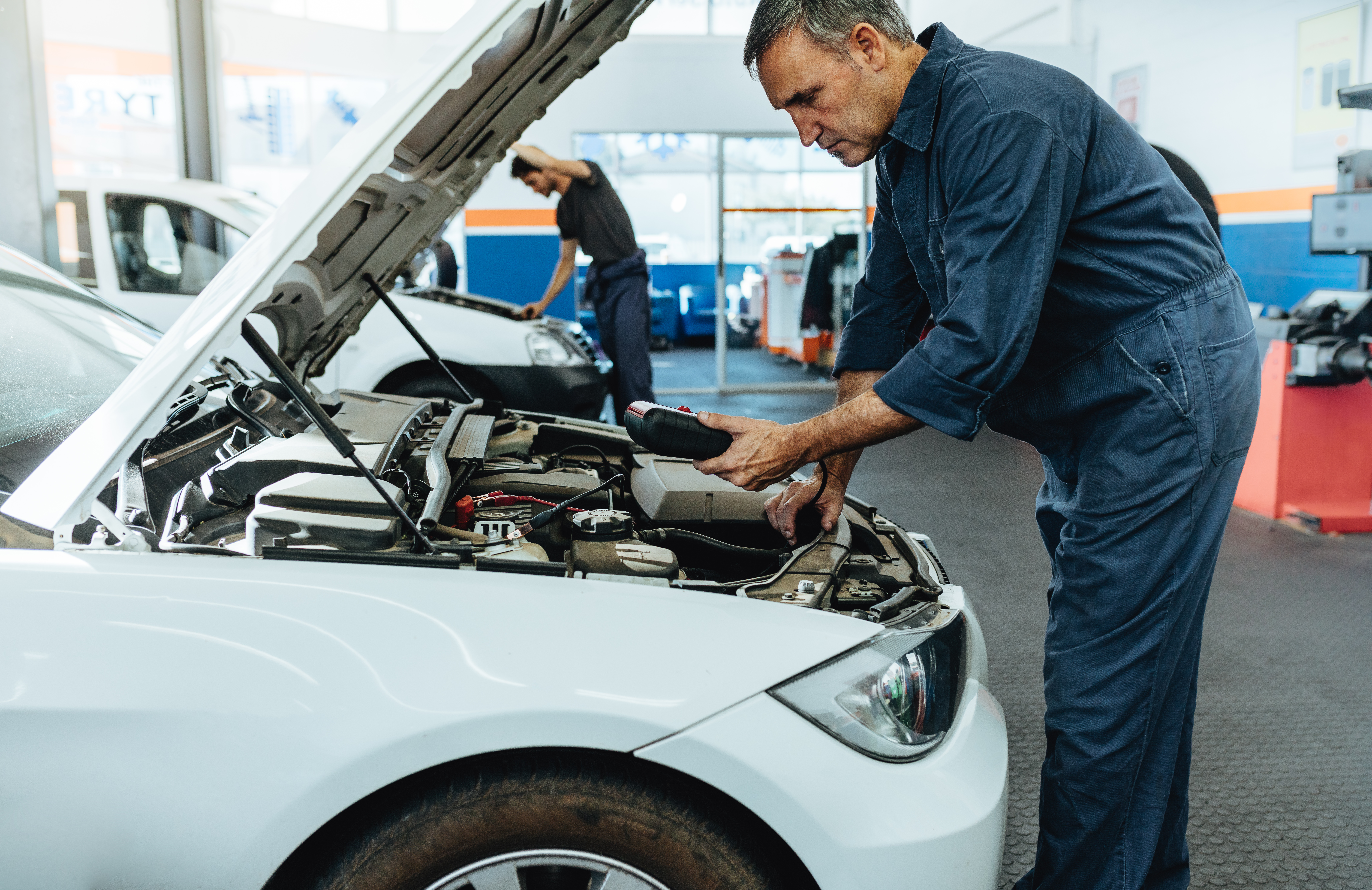 Mechanic reading the error codes with diagnostic device