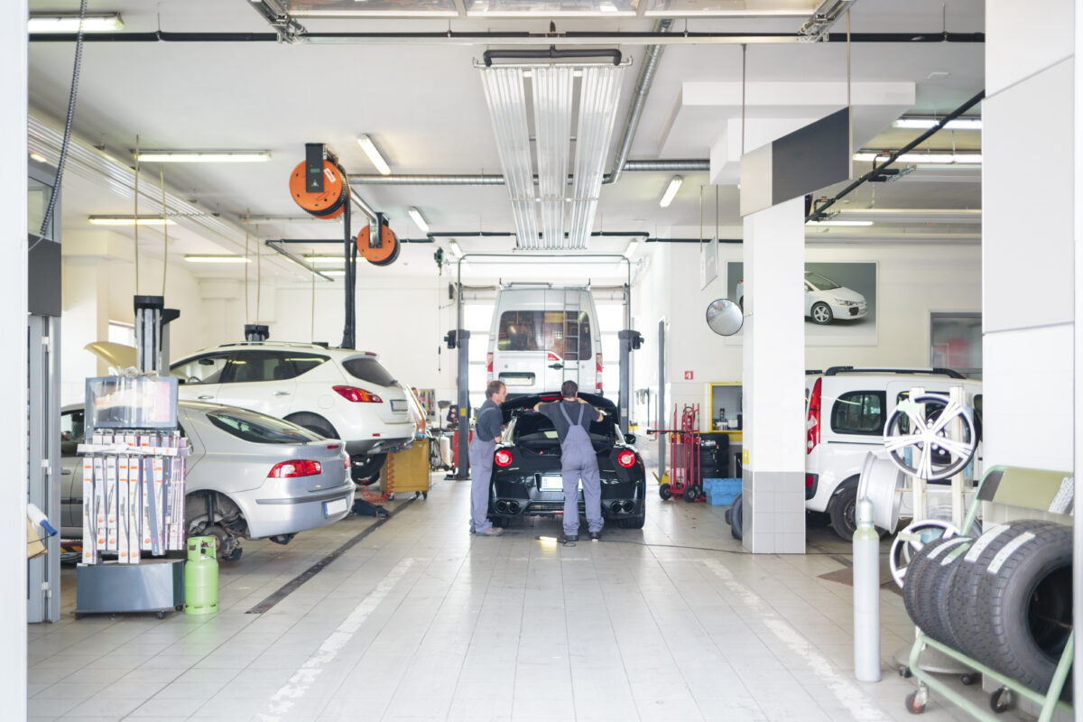 Auto repair shop with car serviced by mechanics